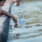 asian-boy-playing-paper-boat-river_1150-7532